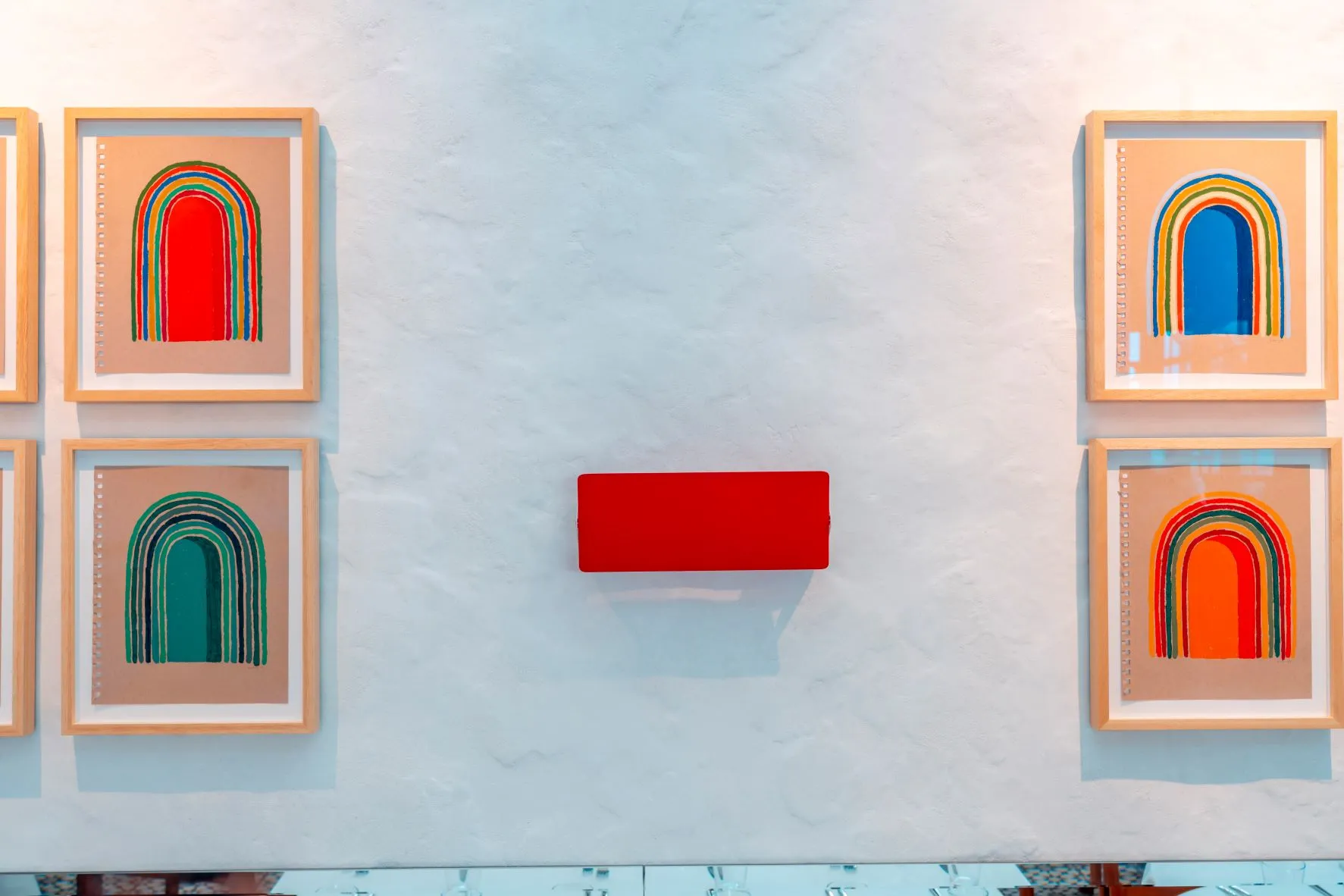 Textured white plaster wall at Pecan Square Cafe with colorful Matt Kleberg drawings.